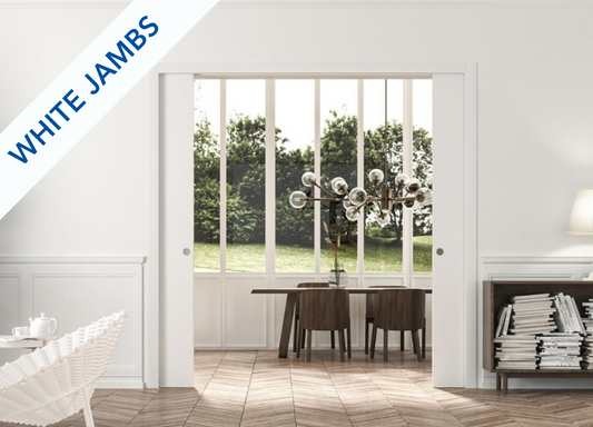 An Eclisse double pocket door system in a room with white wood panelling and architrave but contemporary furniture and lighting