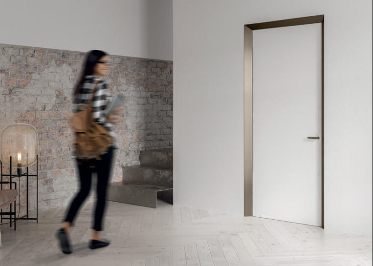 Woman walking through a modern living room with a white door.
